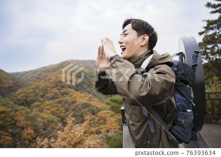 Asian handsome man trekking, climbing autumn mountain Asian handsome man trekking, climbing autumn mountain 76393634