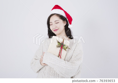 Asian female model with long hair wearing Santa hat, winter Christmas beauty promotion concept Asian female model with long hair wearing Santa hat, winter Christmas beauty promotion concept 76393653