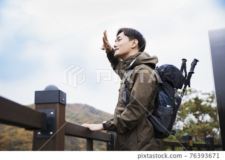 Asian handsome man trekking, climbing autumn mountain Asian handsome man trekking, climbing autumn mountain 76393671