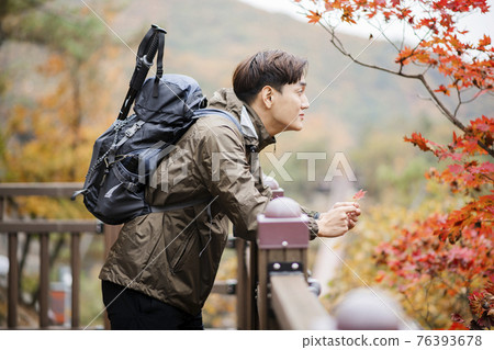 Asian handsome man with mask trekking, climbing autumn mountain Asian handsome man with mask trekking, climbing autumn mountain 76393678