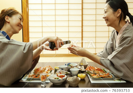 母親倒啤酒，女兒端著玻璃杯 76393753