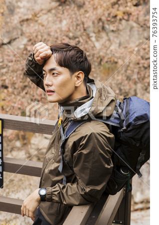 Asian handsome man trekking, climbing autumn mountain Asian handsome man trekking, climbing autumn mountain 76393754
