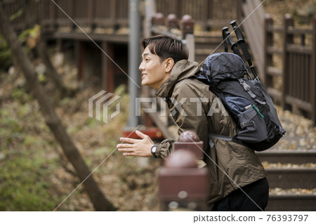 Asian handsome man trekking, climbing autumn mountain Asian handsome man trekking, climbing autumn mountain 76393797