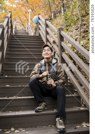 Asian handsome man trekking, climbing autumn mountain Asian handsome man trekking, climbing autumn mountain 76393826