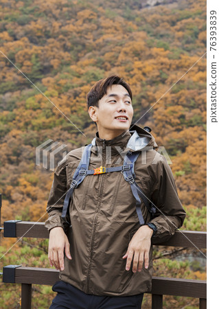 Asian handsome man trekking, climbing autumn mountain Asian handsome man trekking, climbing autumn mountain 76393839
