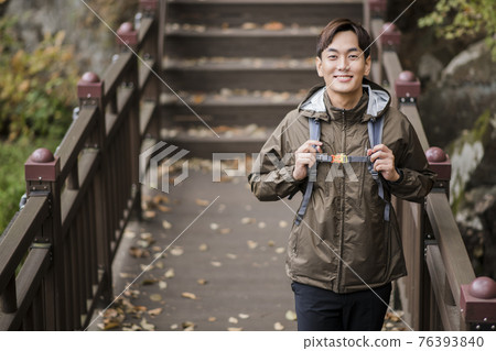 Asian handsome man trekking, climbing autumn mountain Asian handsome man trekking, climbing autumn mountain 76393840