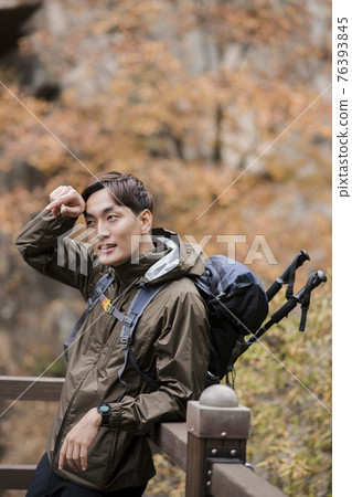 Asian handsome man trekking, climbing autumn mountain Asian handsome man trekking, climbing autumn mountain 76393845