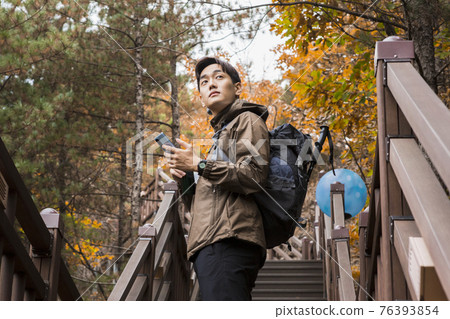 Asian handsome man trekking, climbing autumn mountain Asian handsome man trekking, climbing autumn mountain 76393854