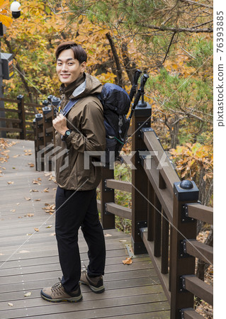 Asian handsome man trekking, climbing autumn mountain Asian handsome man trekking, climbing autumn mountain 76393885
