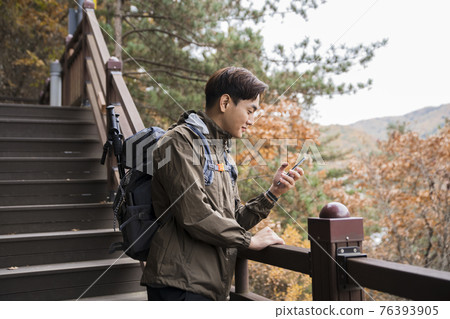 Asian handsome man trekking, climbing autumn mountain Asian handsome man trekking, climbing autumn mountain 76393905