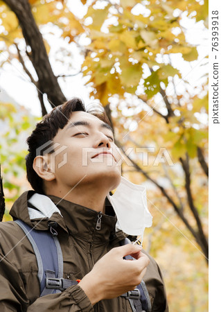 Asian handsome man with mask trekking, climbing autumn mountain Asian handsome man with mask trekking, climbing autumn mountain 76393918