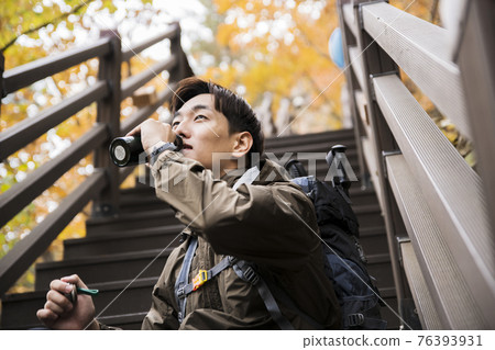 Asian handsome man trekking, climbing autumn mountain Asian handsome man trekking, climbing autumn mountain 76393931