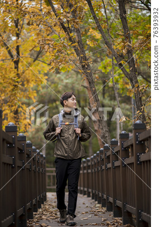 Asian handsome man trekking, climbing autumn mountain Asian handsome man trekking, climbing autumn mountain 76393932