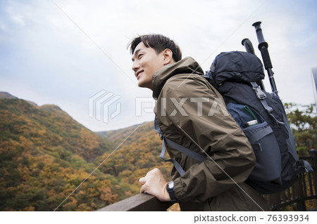 Asian handsome man trekking, climbing autumn mountain Asian handsome man trekking, climbing autumn mountain 76393934