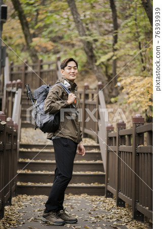 Asian handsome man trekking, climbing autumn mountain Asian handsome man trekking, climbing autumn mountain 76393939