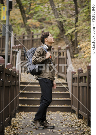 Asian handsome man trekking, climbing autumn mountain Asian handsome man trekking, climbing autumn mountain 76393940