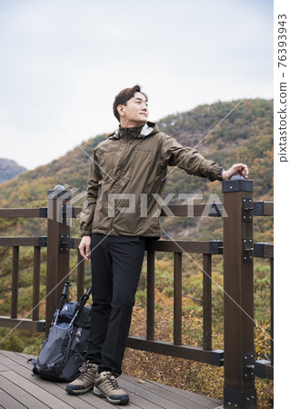 Asian handsome man trekking, climbing autumn mountain Asian handsome man trekking, climbing autumn mountain 76393943