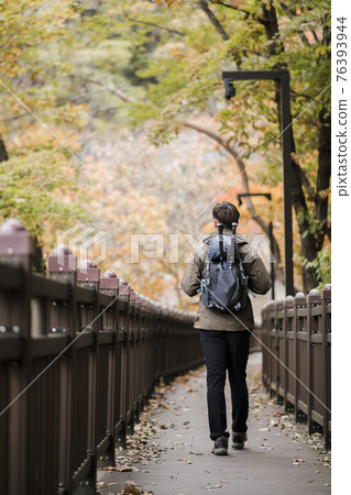Asian handsome man trekking, climbing autumn mountain 76393944