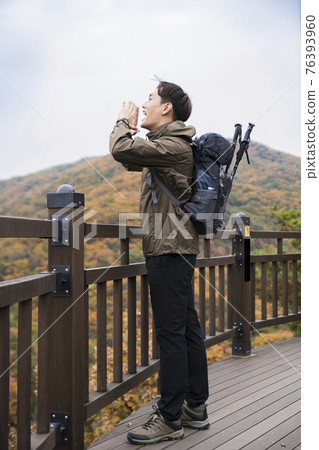 Asian handsome man trekking, climbing autumn mountain Asian handsome man trekking, climbing autumn mountain 76393960