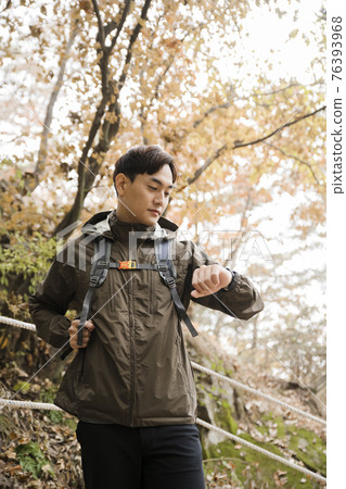 Asian handsome man trekking, climbing autumn mountain Asian handsome man trekking, climbing autumn mountain 76393968