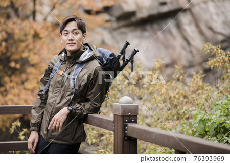 Asian handsome man trekking, climbing autumn mountain Asian handsome man trekking, climbing autumn mountain 76393969