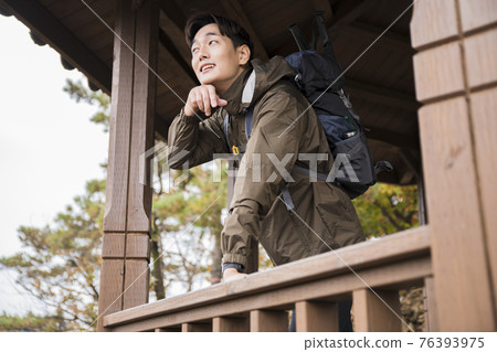 Asian handsome man trekking, climbing autumn mountain Asian handsome man trekking, climbing autumn mountain 76393975