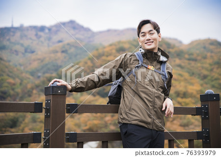 Asian handsome man trekking, climbing autumn mountain Asian handsome man trekking, climbing autumn mountain 76393979