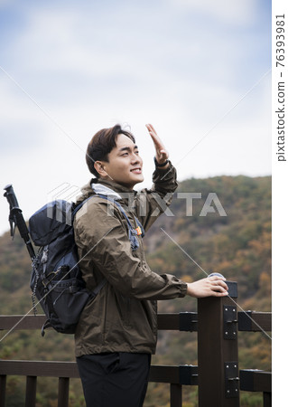 Asian handsome man trekking, climbing autumn mountain Asian handsome man trekking, climbing autumn mountain 76393981