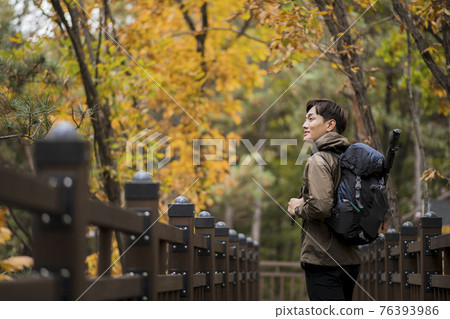 Asian handsome man trekking, climbing autumn mountain Asian handsome man trekking, climbing autumn mountain 76393986