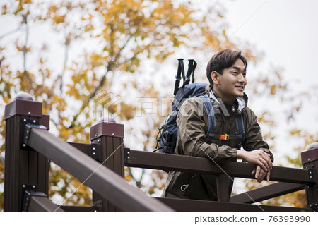 Asian handsome man trekking, climbing autumn mountain Asian handsome man trekking, climbing autumn mountain 76393990