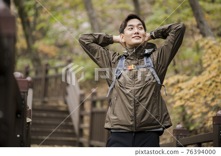 Asian handsome man trekking, climbing autumn mountain Asian handsome man trekking, climbing autumn mountain 76394000