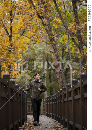 Asian handsome man trekking, climbing autumn mountain 76394002