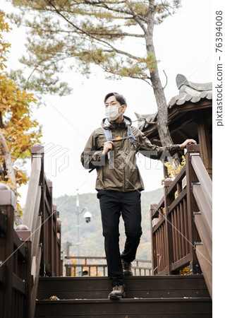 Asian handsome man with mask trekking, climbing autumn mountain Asian handsome man with mask trekking, climbing autumn mountain 76394008