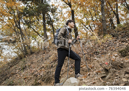Asian handsome man trekking, climbing autumn mountain Asian handsome man trekking, climbing autumn mountain 76394046