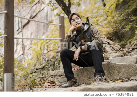 Asian handsome man trekking, climbing autumn mountain 76394051