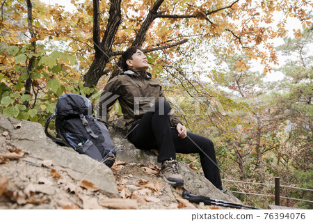 Asian handsome man trekking, climbing autumn mountain Asian handsome man trekking, climbing autumn mountain 76394076