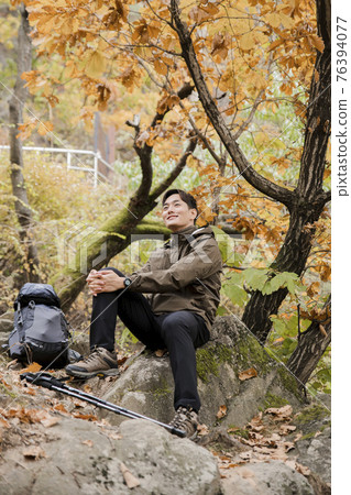 Asian handsome man trekking, climbing autumn mountain Asian handsome man trekking, climbing autumn mountain 76394077