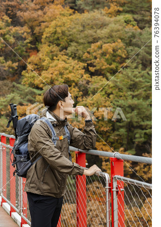 Asian handsome man with mask trekking, climbing autumn mountain Asian handsome man with mask trekking, climbing autumn mountain 76394078