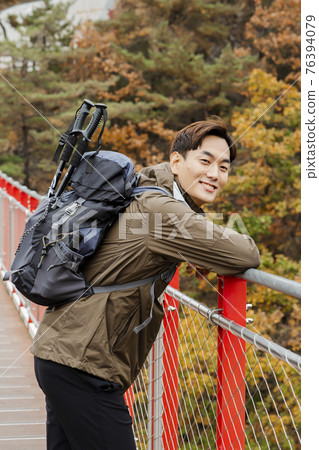 Asian handsome man with mask trekking, climbing autumn mountain Asian handsome man with mask trekking, climbing autumn mountain 76394079