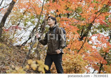 Asian handsome man trekking, climbing autumn mountain Asian handsome man trekking, climbing autumn mountain 76394081