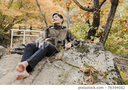 Asian handsome man trekking, climbing autumn mountain Asian handsome man trekking, climbing autumn mountain 76394082