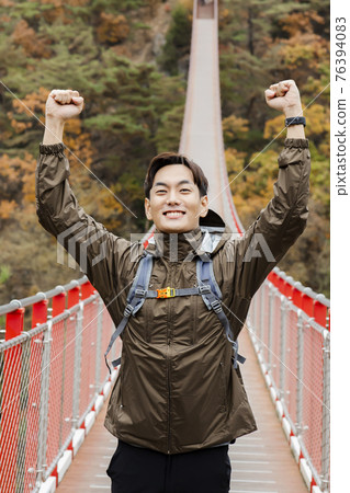 Asian handsome man with mask trekking, climbing autumn mountain Asian handsome man with mask trekking, climbing autumn mountain 76394083