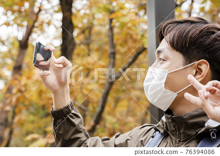 Asian handsome man with mask trekking, climbing autumn mountain Asian handsome man with mask trekking, climbing autumn mountain 76394086