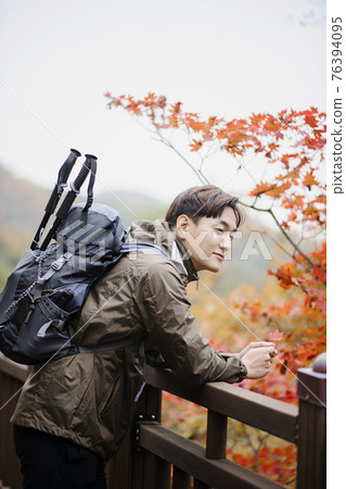 Asian handsome man with mask trekking, climbing autumn mountain Asian handsome man with mask trekking, climbing autumn mountain 76394095