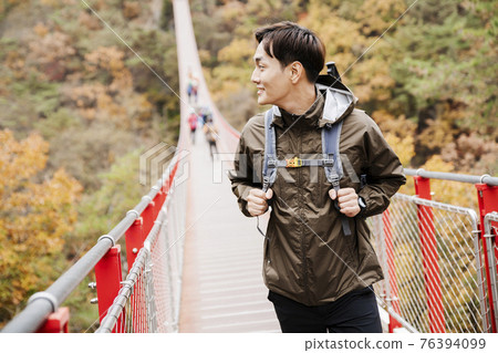 Asian handsome man with mask trekking, climbing autumn mountain Asian handsome man with mask trekking, climbing autumn mountain 76394099