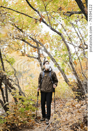 Asian handsome man with mask trekking, climbing autumn mountain Asian handsome man with mask trekking, climbing autumn mountain 76394122