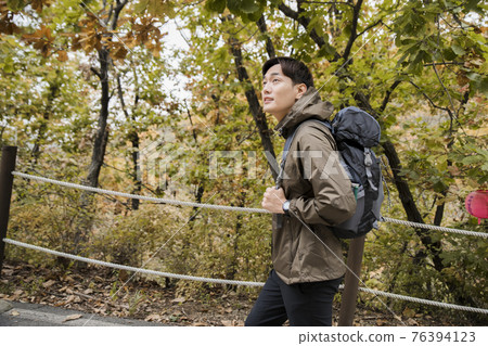 Asian handsome man trekking, climbing autumn mountain Asian handsome man trekking, climbing autumn mountain 76394123