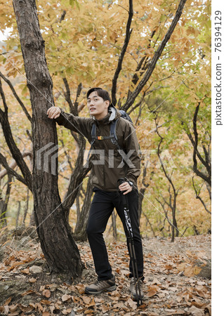 Asian handsome man trekking, climbing autumn mountain Asian handsome man trekking, climbing autumn mountain 76394129