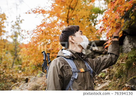 Asian handsome man with mask trekking, climbing autumn mountain Asian handsome man with mask trekking, climbing autumn mountain 76394130