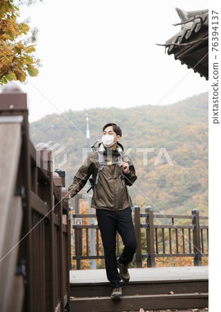 Asian handsome man with mask trekking, climbing autumn mountain Asian handsome man with mask trekking, climbing autumn mountain 76394137